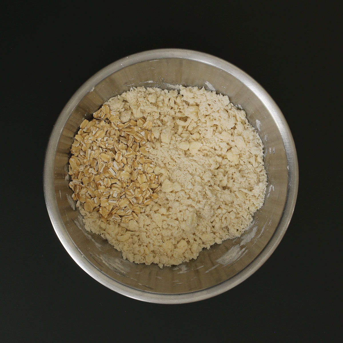 oats adding to mixing bowl with dry ingredients.