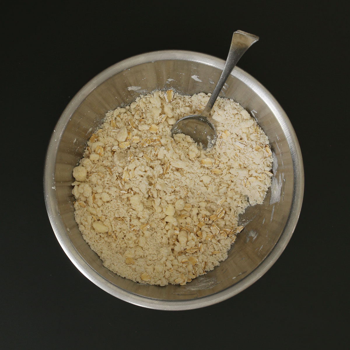 spoon stirring together the oats and butter crumb mixture.
