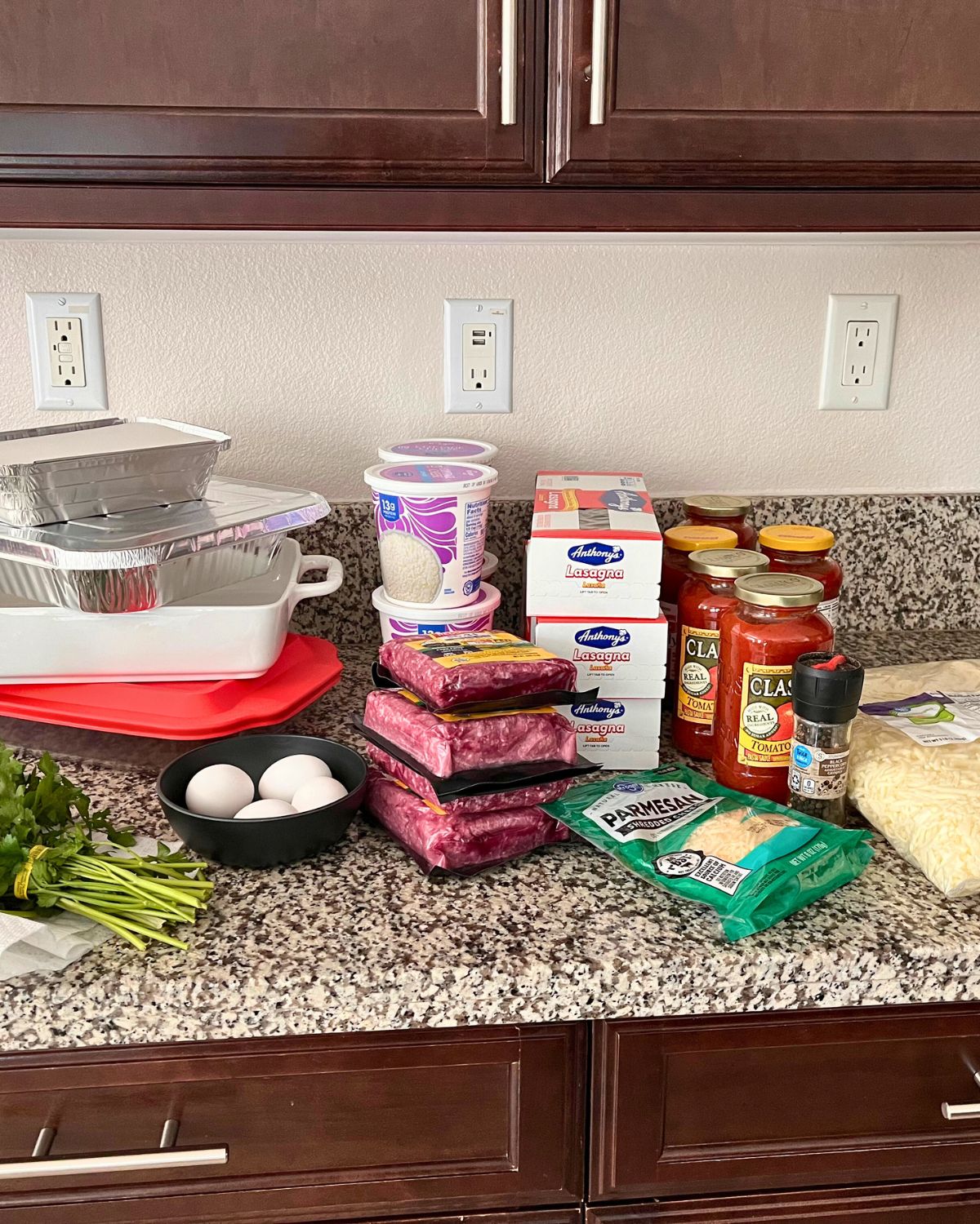 ingredients for making many batches of lasagna on counter.