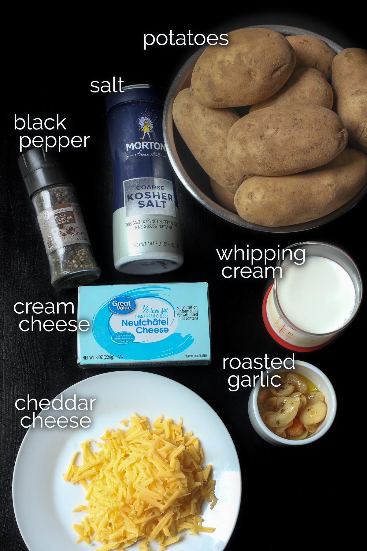 ingredients for mashed potato casserole laid out on a black work surface.