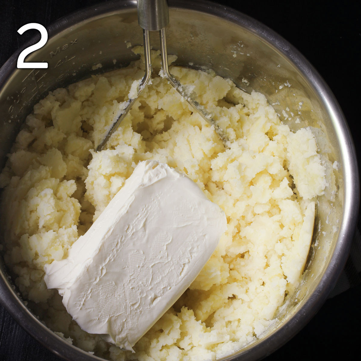 adding cream cheese to the mashed potatoes.