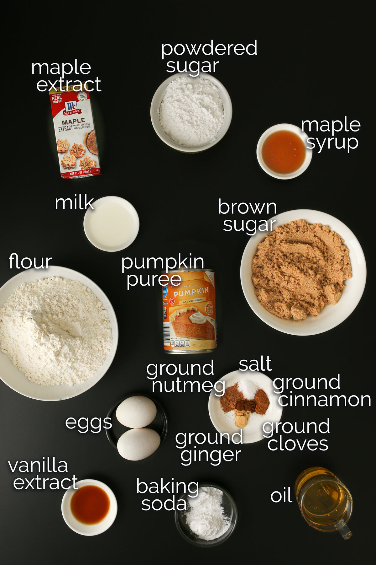 ingredients for spiced pumpkin bundt cake measured and laid out on a black table top.