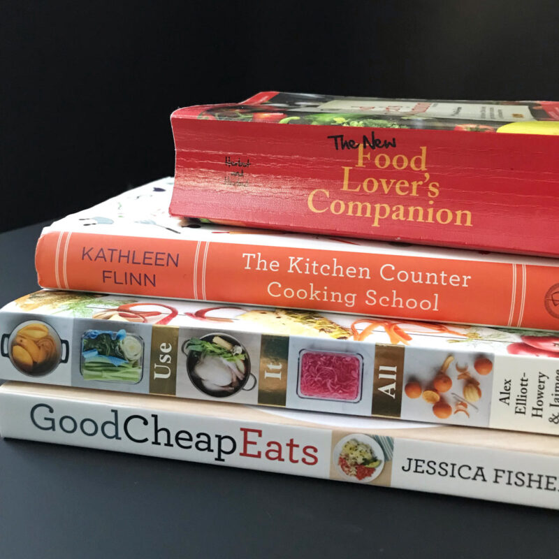 stack of books for kitchen gift ideas on black table.