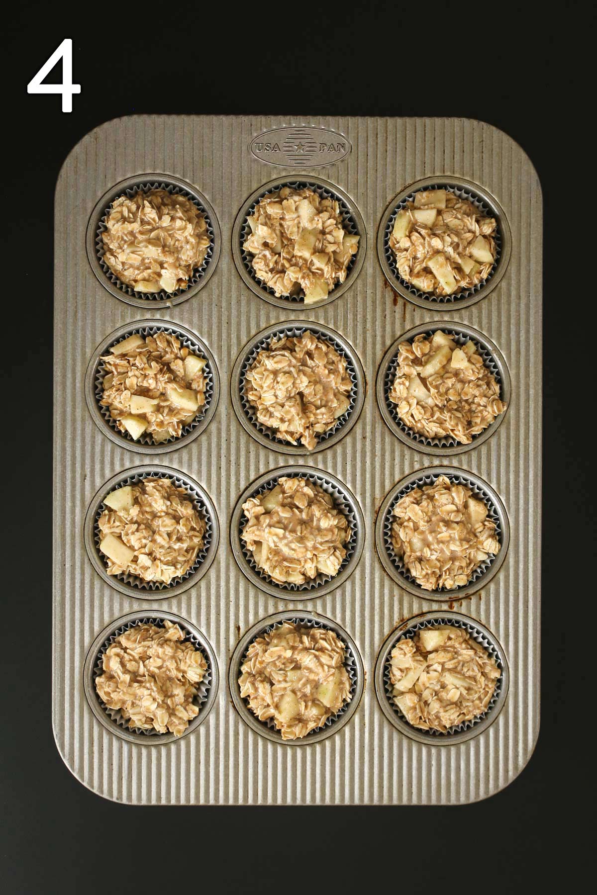 cups of muffin pan lined with parchment and filled with oat mixture.