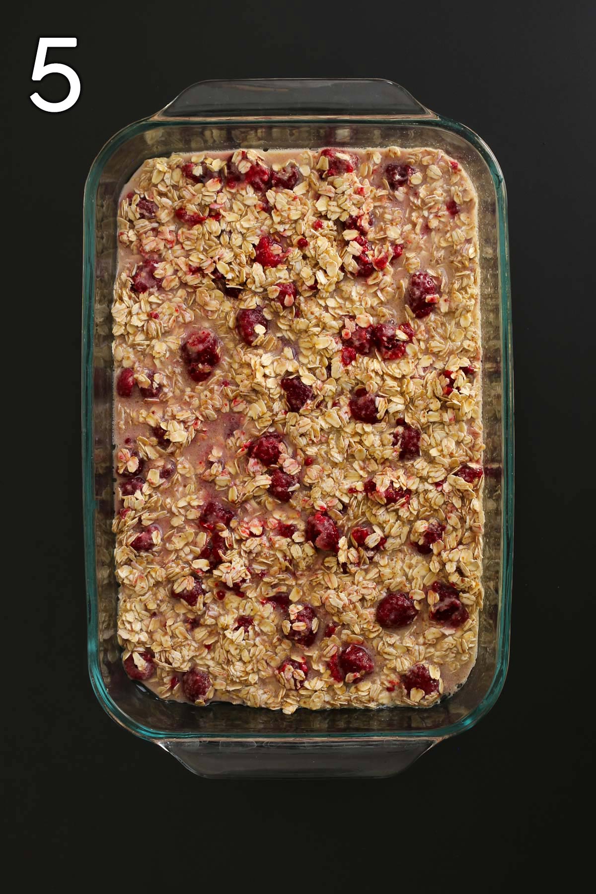 oatmeal mixture spooned into 9x13-inch pan on black table top.