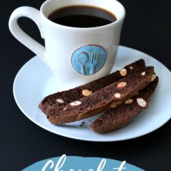 mug of coffee with a teal medallion on it, on a plate with three chocolate biscotti, with text overlay.