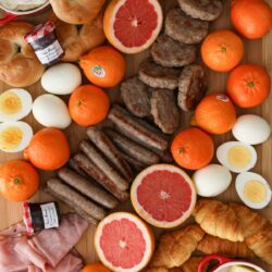 closeup overhead shot of breakfast items on wooden charcuterie board.