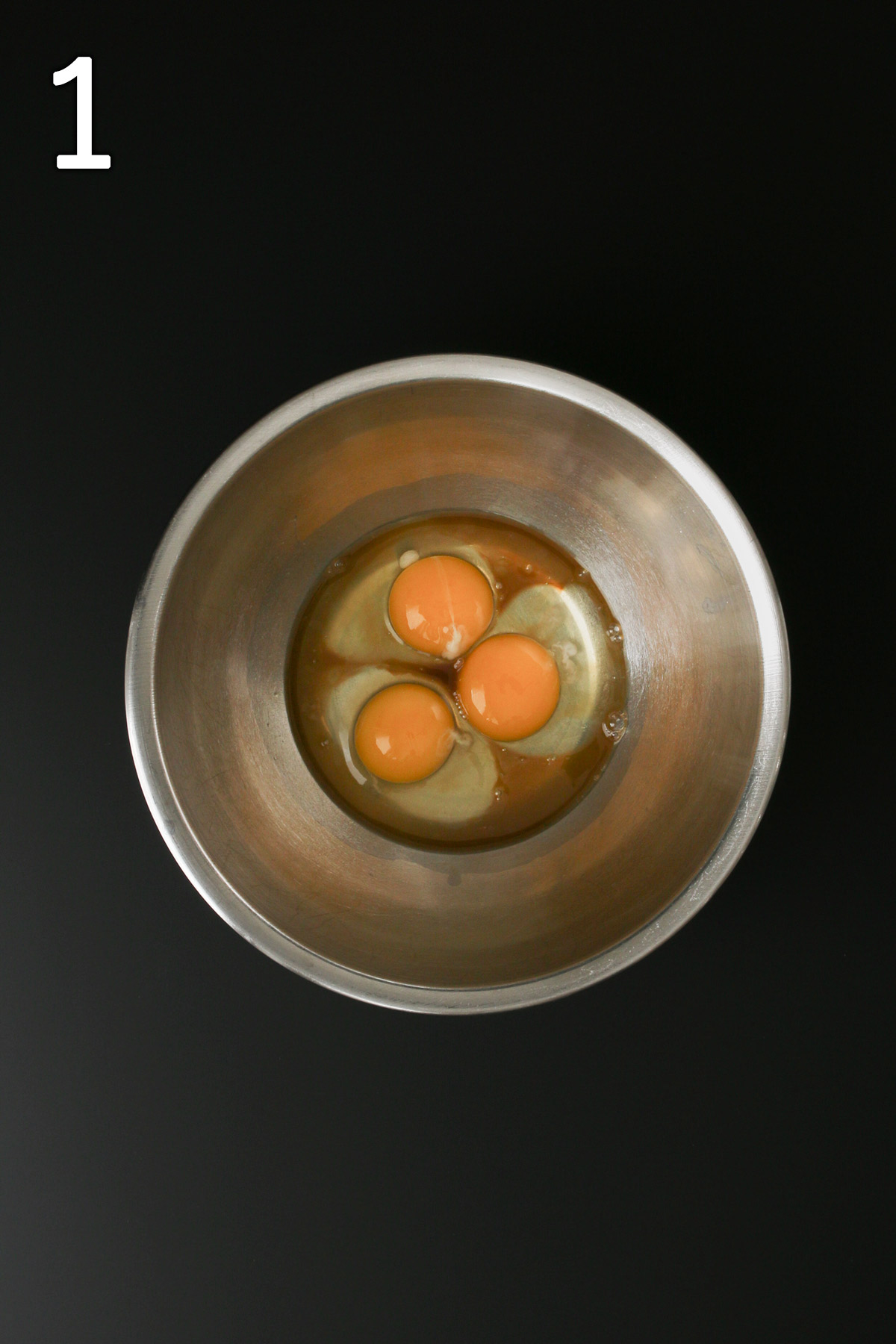 eggs and extracts in stainless steel mixing bowl.