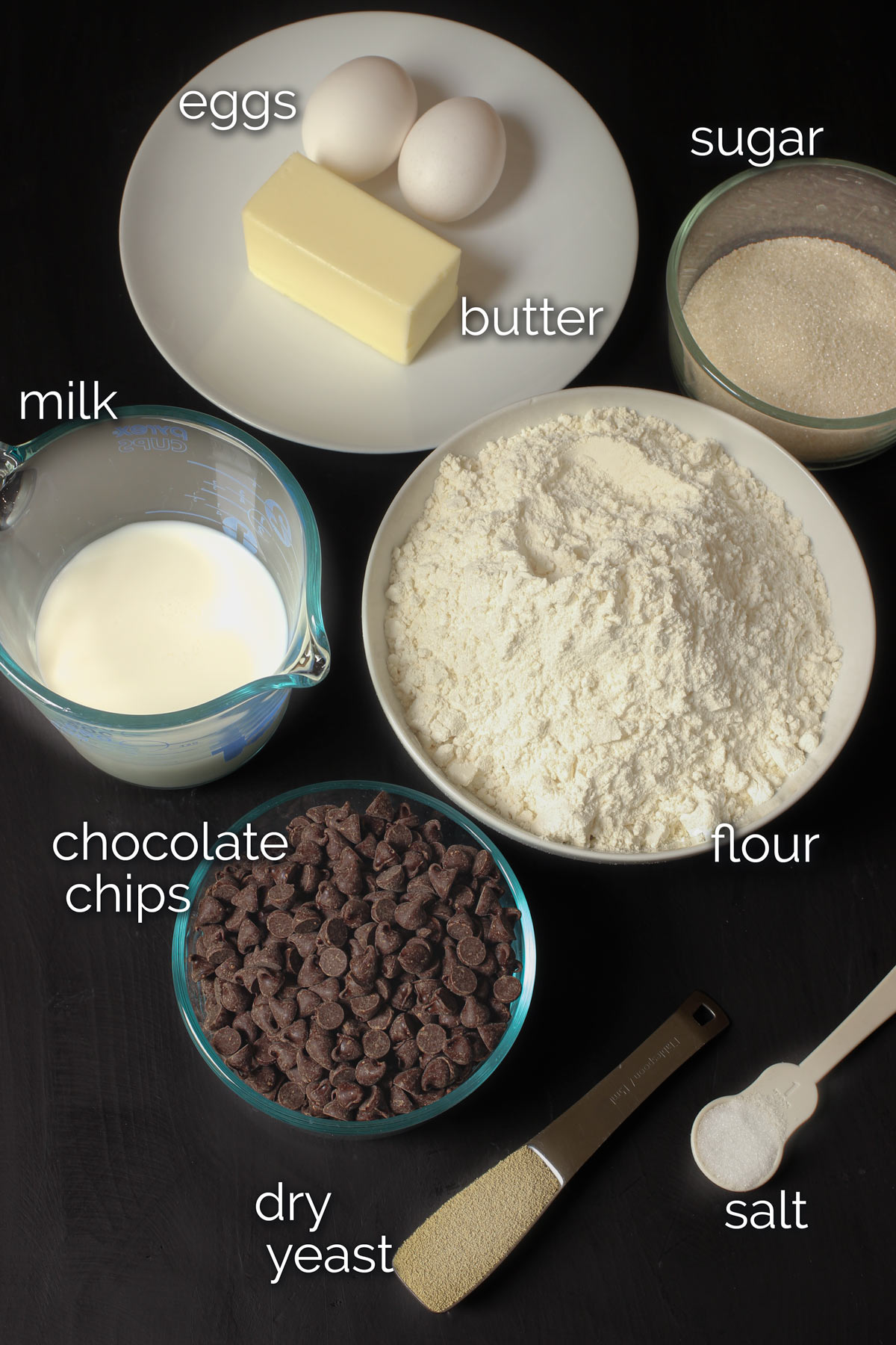 ingredients for chocolate butterhorn pastries measured out on a black table top.