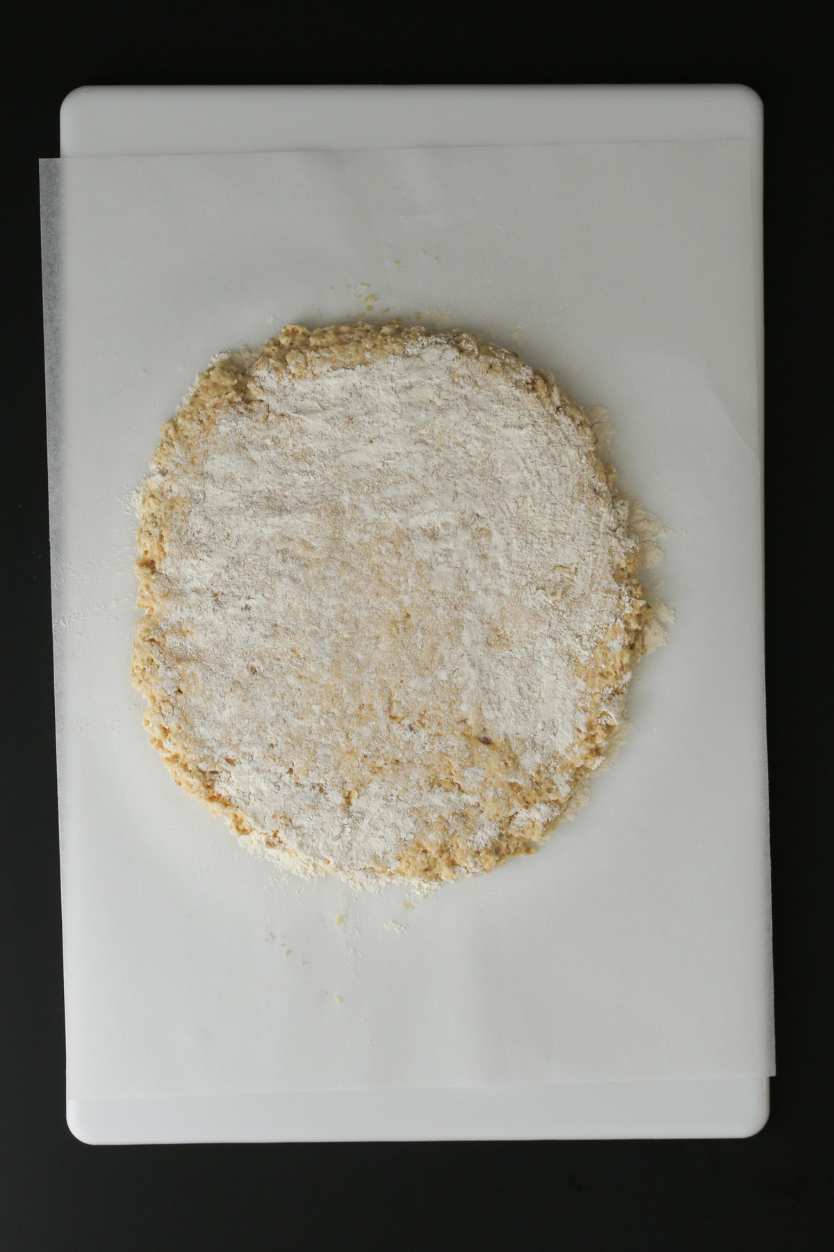 dough patted into a round on parchment paper.