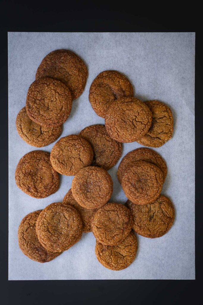 pile of molasses crinkles on parchment paper.