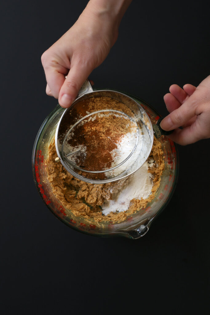 sifting in flour and spices to butter mixture.