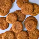 molasses cookies spread on parchment paper.