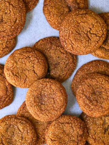 molasses cookies spread on parchment paper.