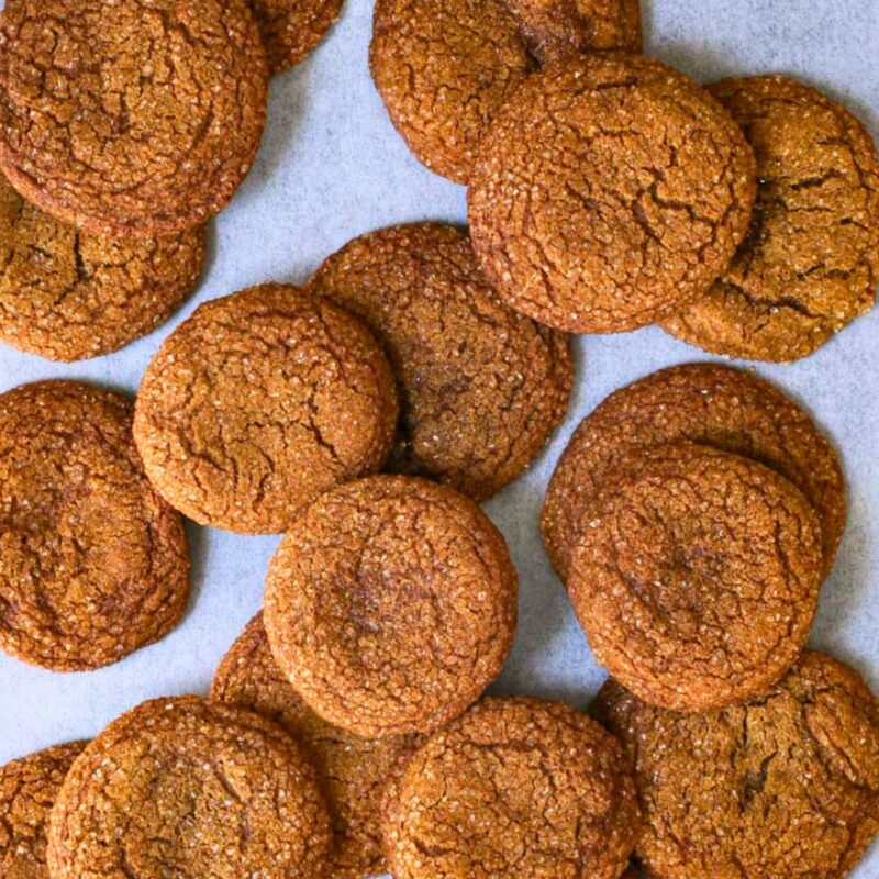 molasses cookies spread on parchment paper.