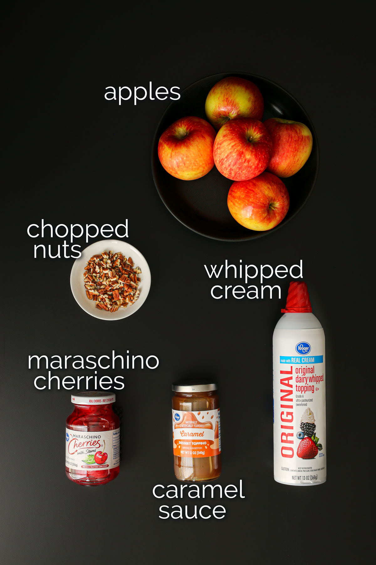 ingredients for apple slices with caramel laid out on black table top.