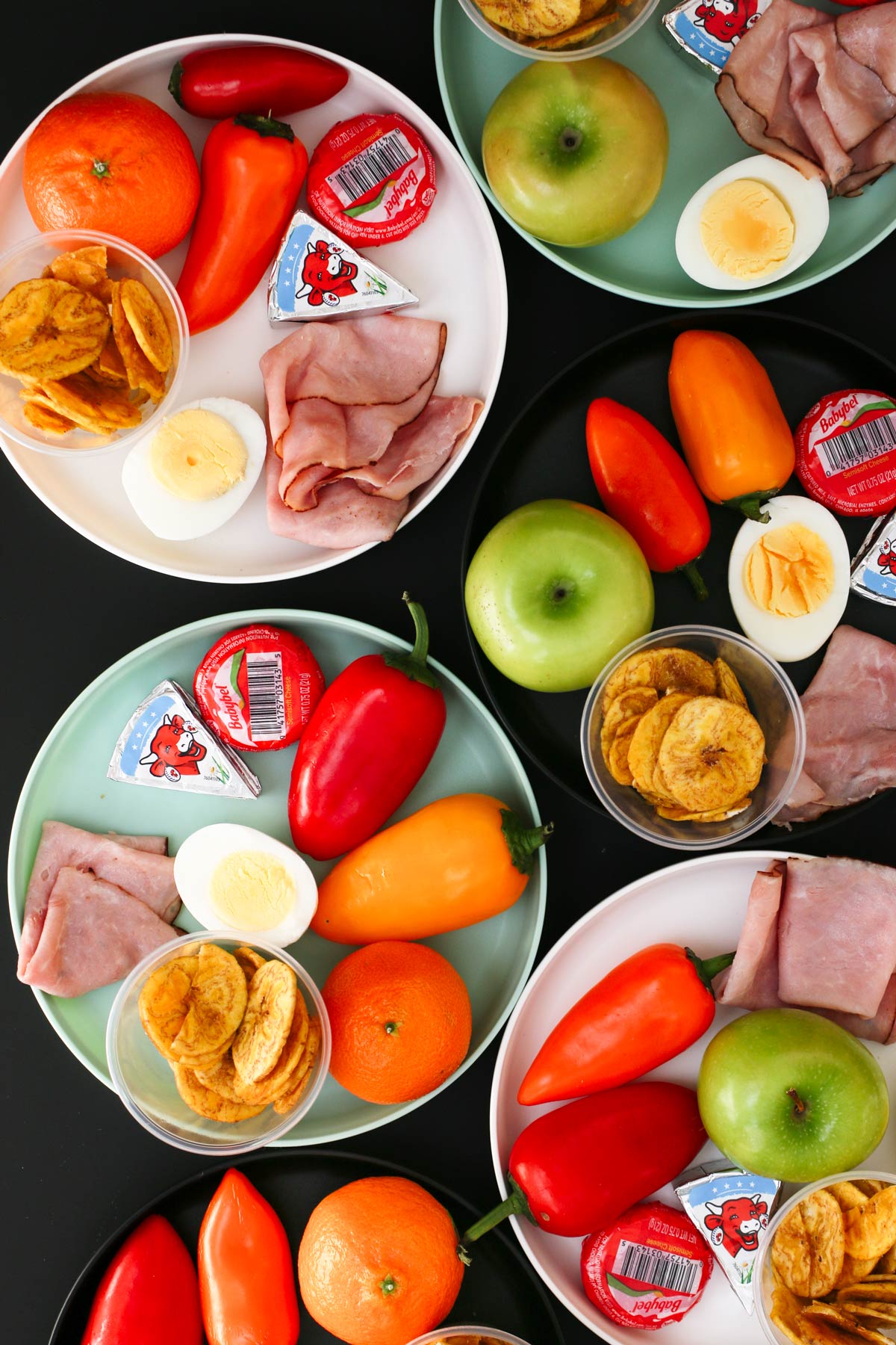 array of small plates with snacks on them.