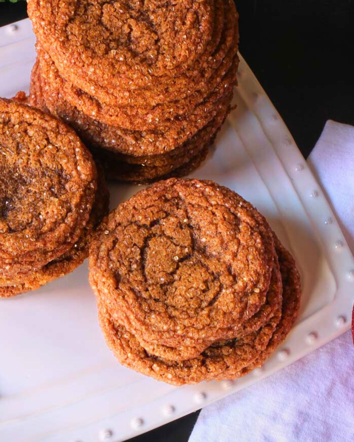 stacked molasses crinkles on white serving tray.