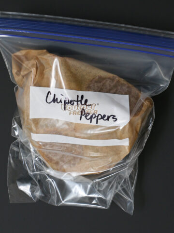bagged and frozen chipotle peppers on a black table.