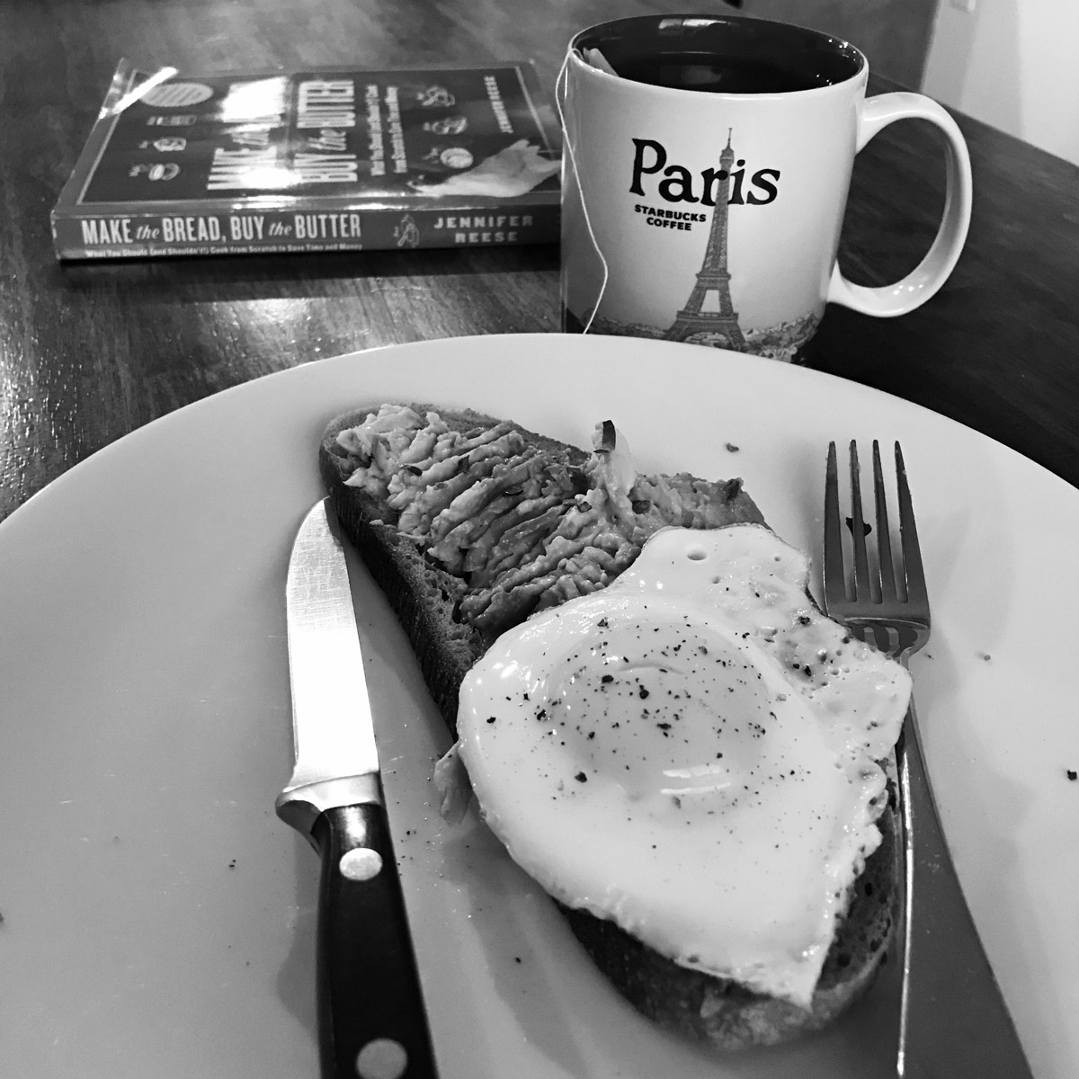 black and white shot of avocado toast on breakfast table.