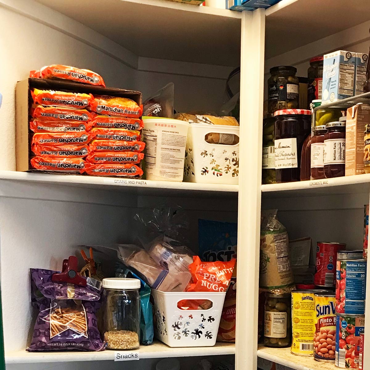 shelves of pantry with grocery items arranged in categories.