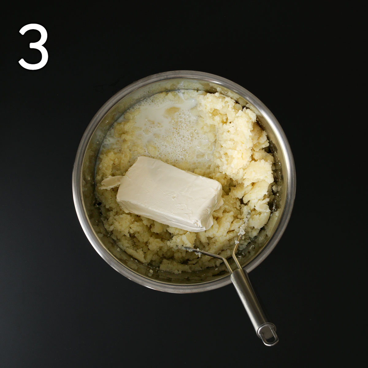 adding milk and cream cheese to the mashed potatoes in the pot.