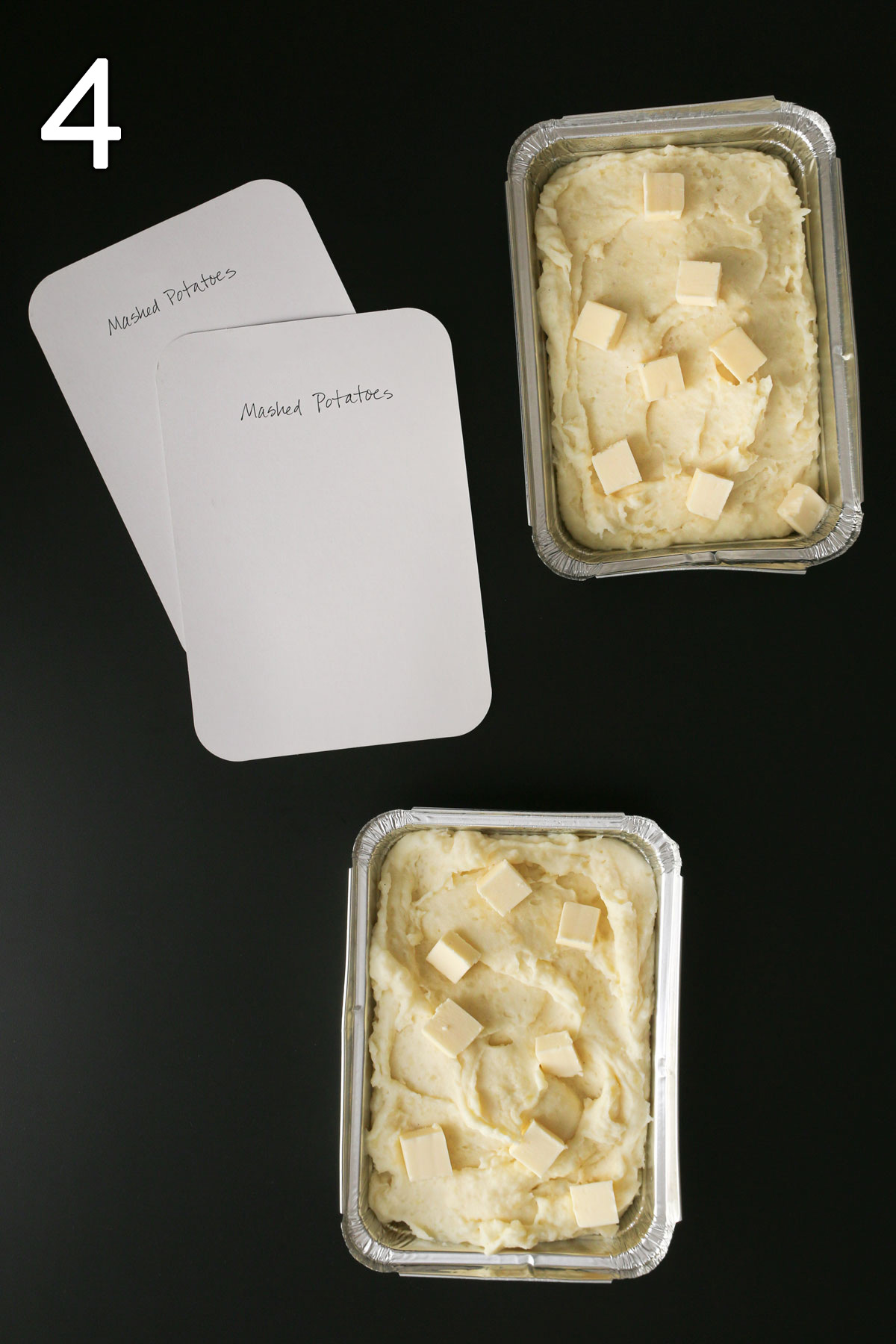 potatoes divided into foil baking pans with labeled lids on the table nearby.