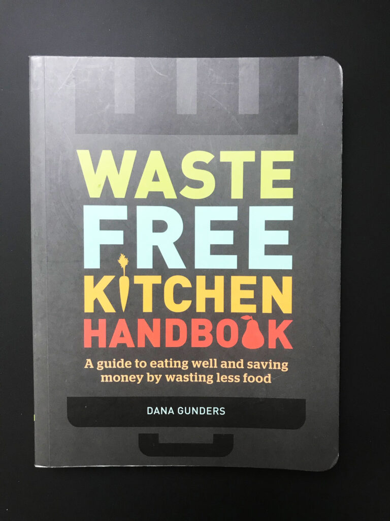 copy of waste-free kitchen handbook on black table top.