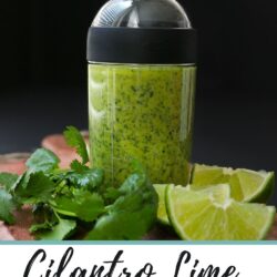 bottle of dressing on a board with lime wedges and cilantro leaves, there is also text overlay.