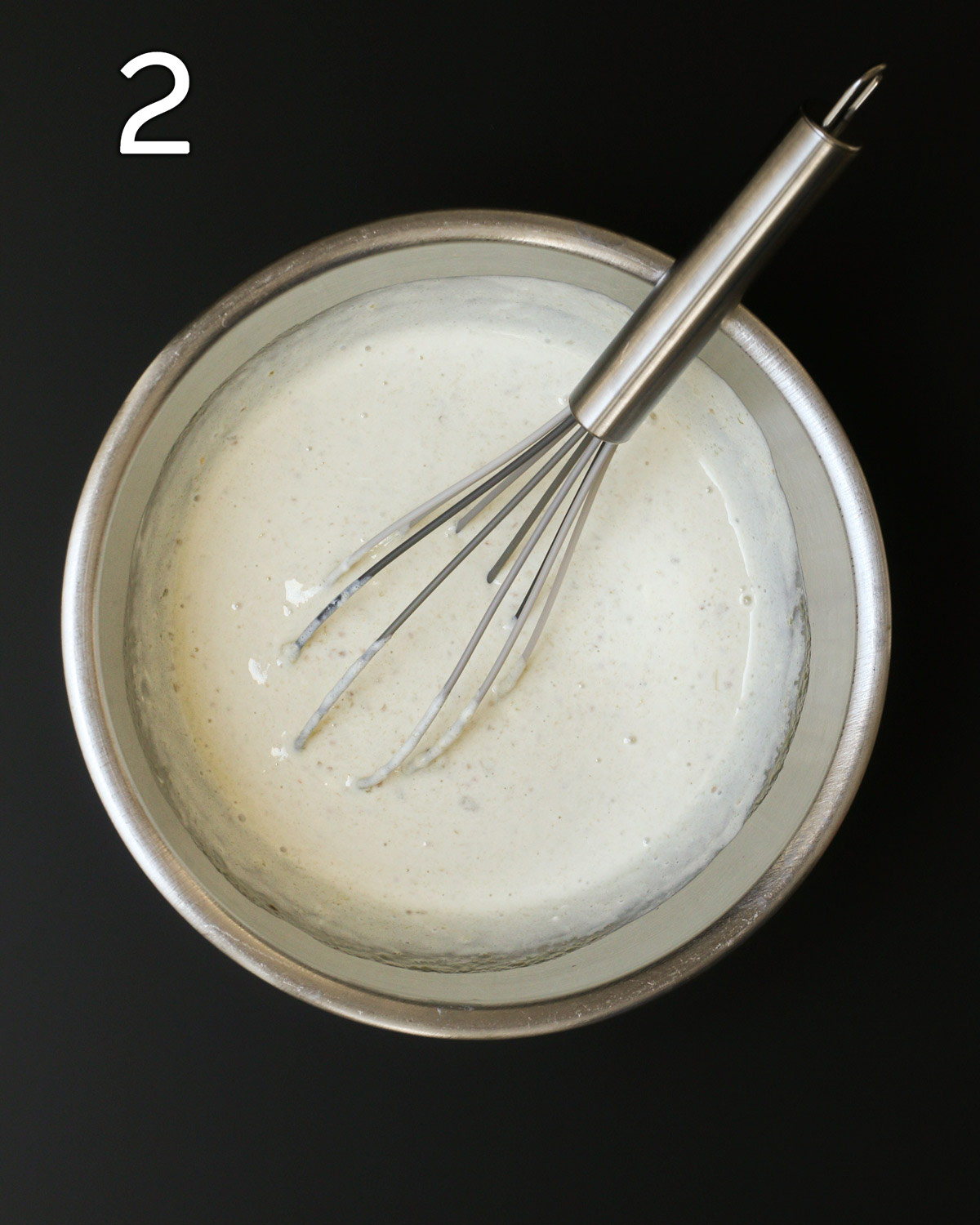 sour cream sauce in metal bowl with metal whisk.