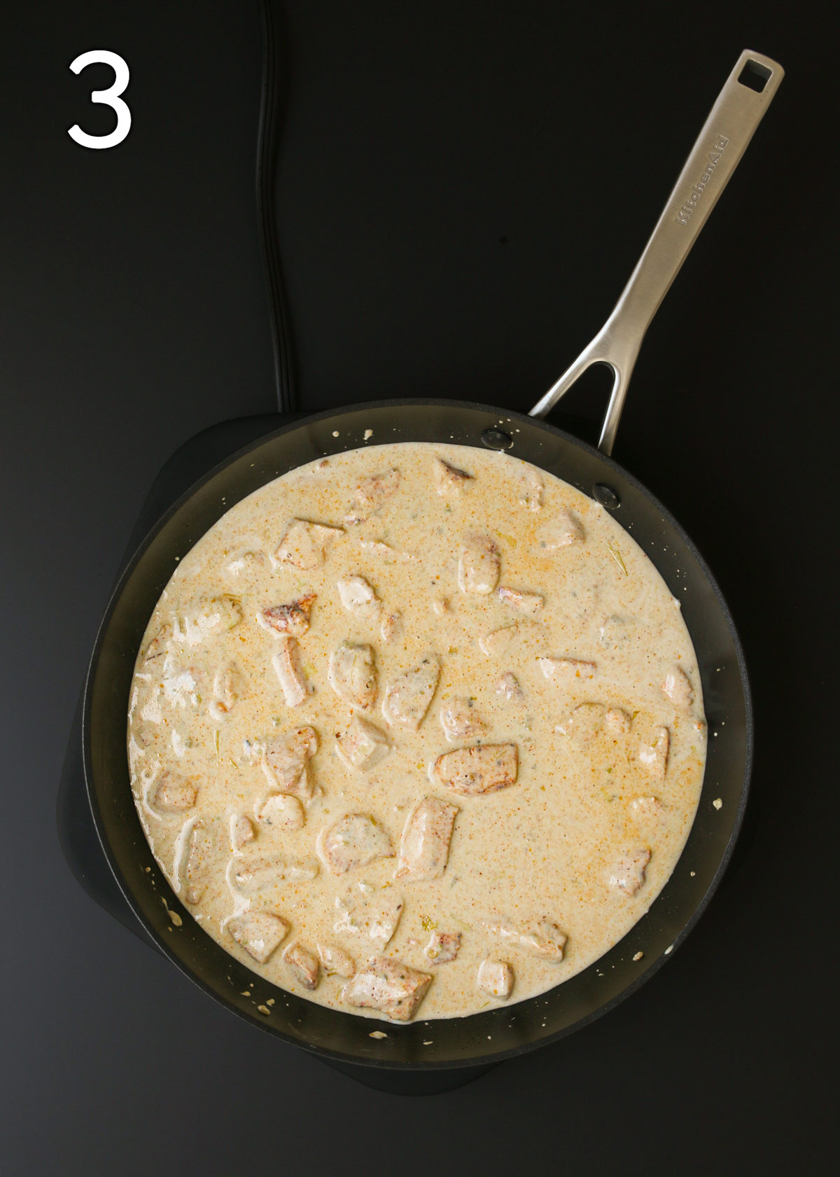 simmered chicken and sauce in skillet.