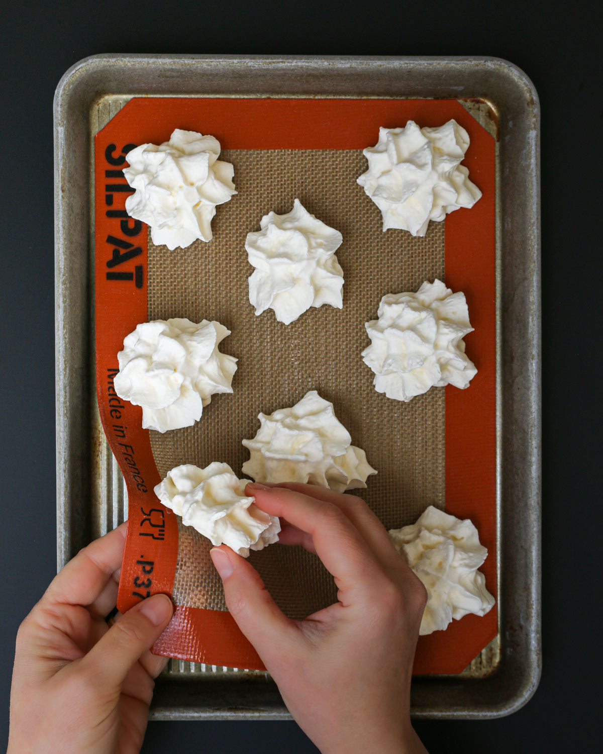 peeling rosettes of frozen whipped cream off a silpat mat.
