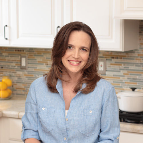 headshot of jessica in the kitchen, wearing a chambray button-down.