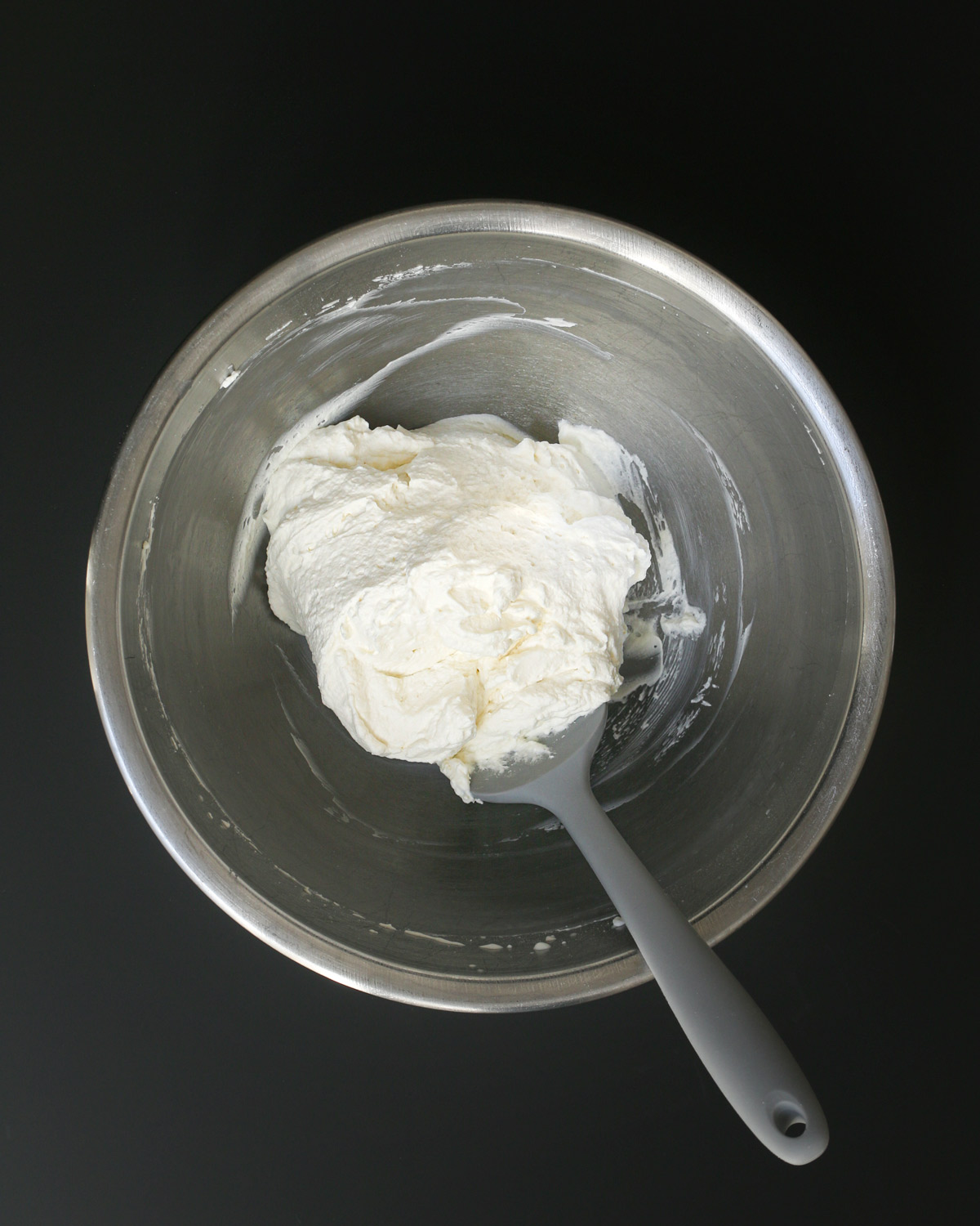 stable whipped cream in metal bowl with a rubber spatula.