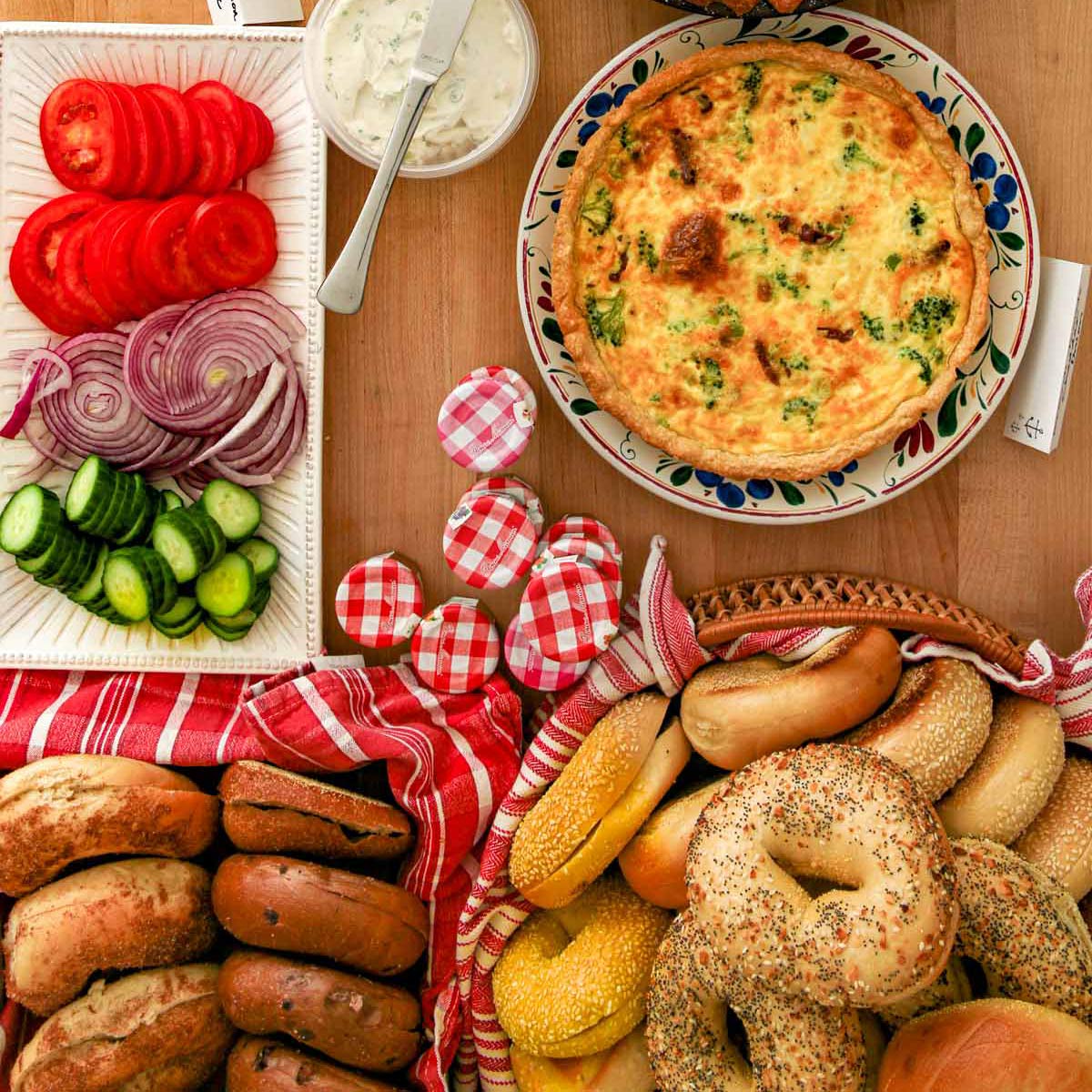 overhead shot of buffet table with quiche, bagels, and bagel toppings.