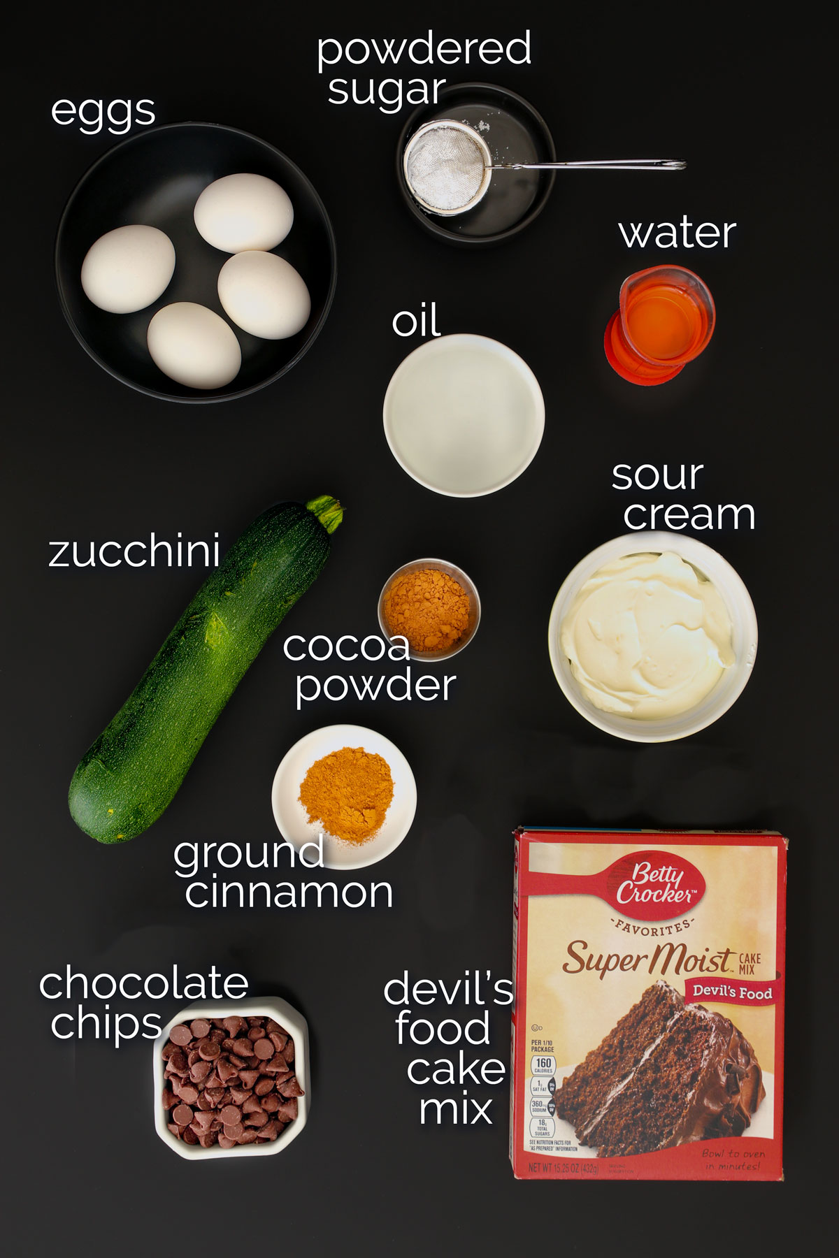 ingredients for chocolate zucchini cake laid out on table top.