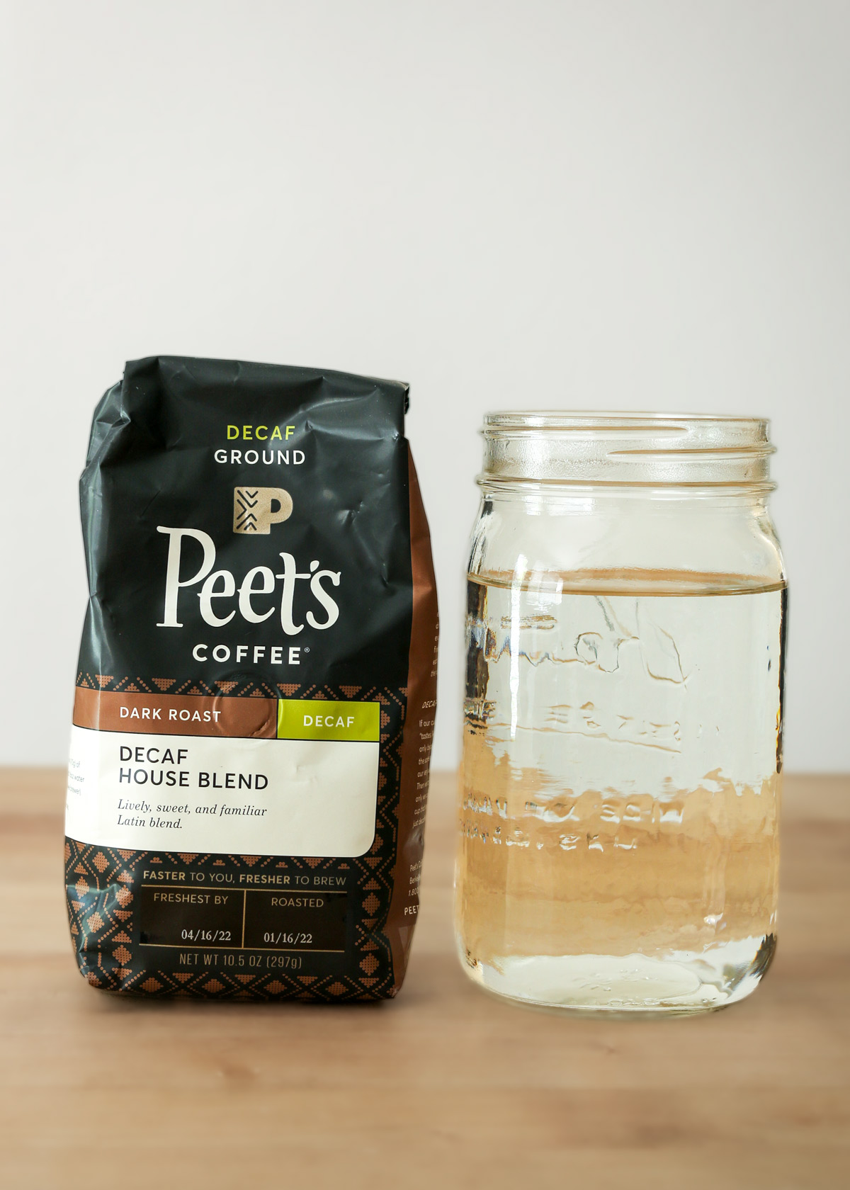 bag of decaf Peets coffee on counter next to quart of water.
