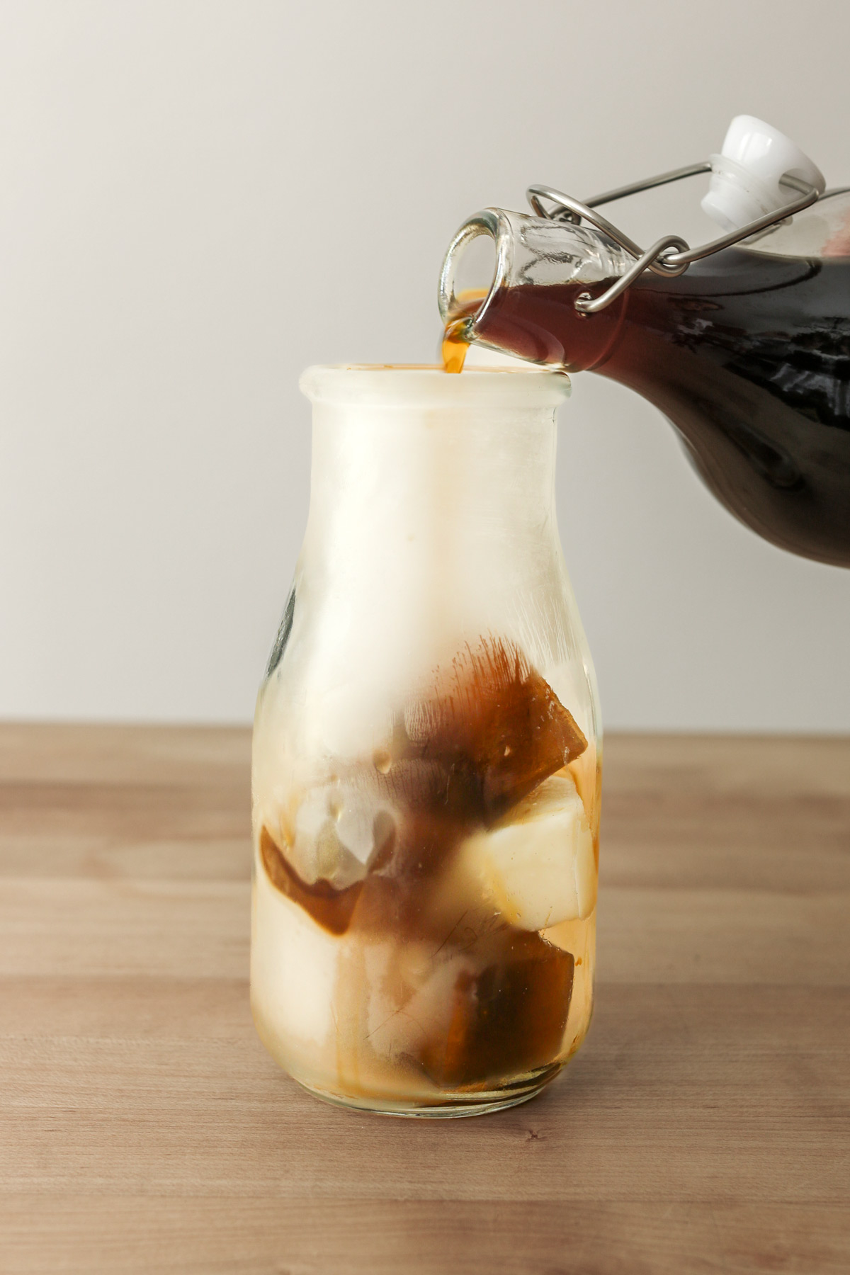 coffee cubes in milk bottle with concentrate being poured into the glass.