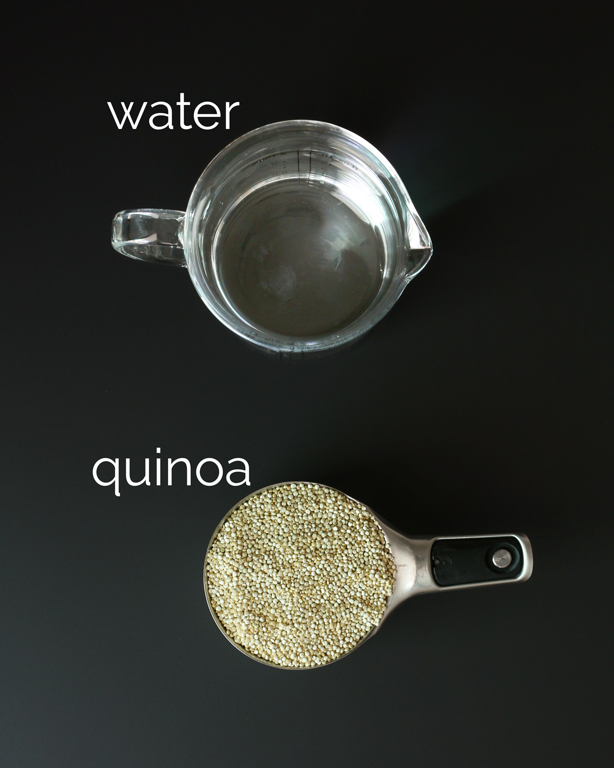 containers of quinoa and water on black table.