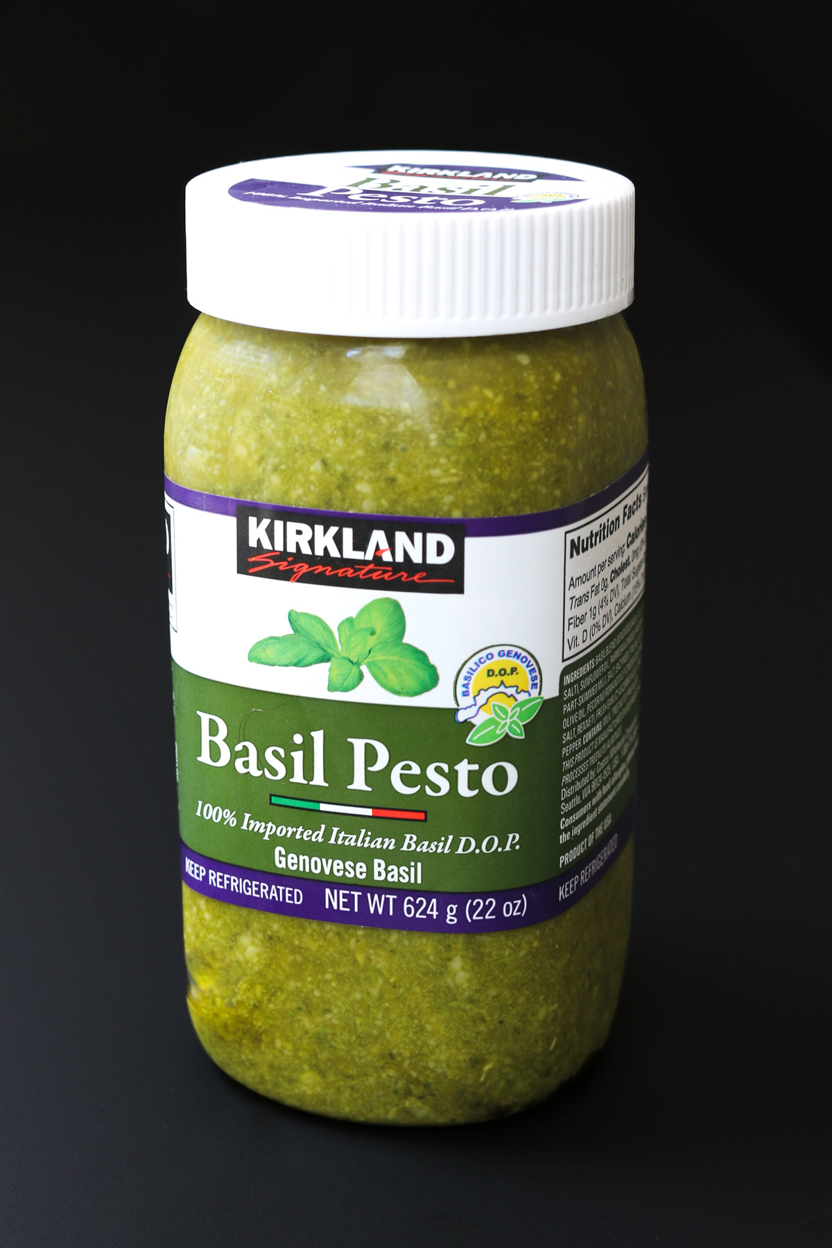 jar of kirkland pesto on a black background.