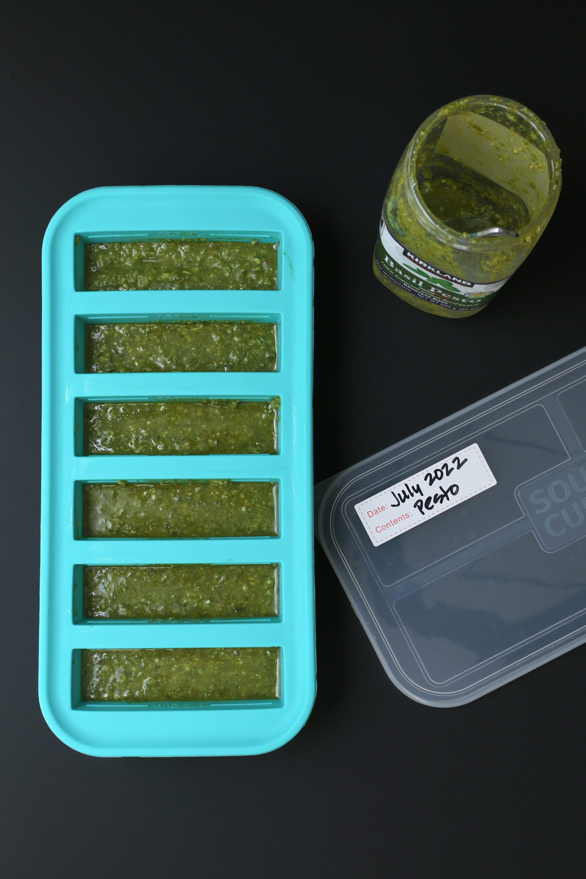 pesto in ½ cup soupercube trays with labeled lid on table.