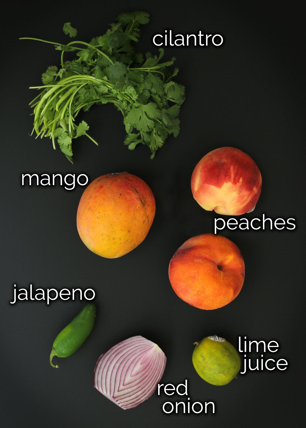 ingredients for mango peach salsa laid out on a table.