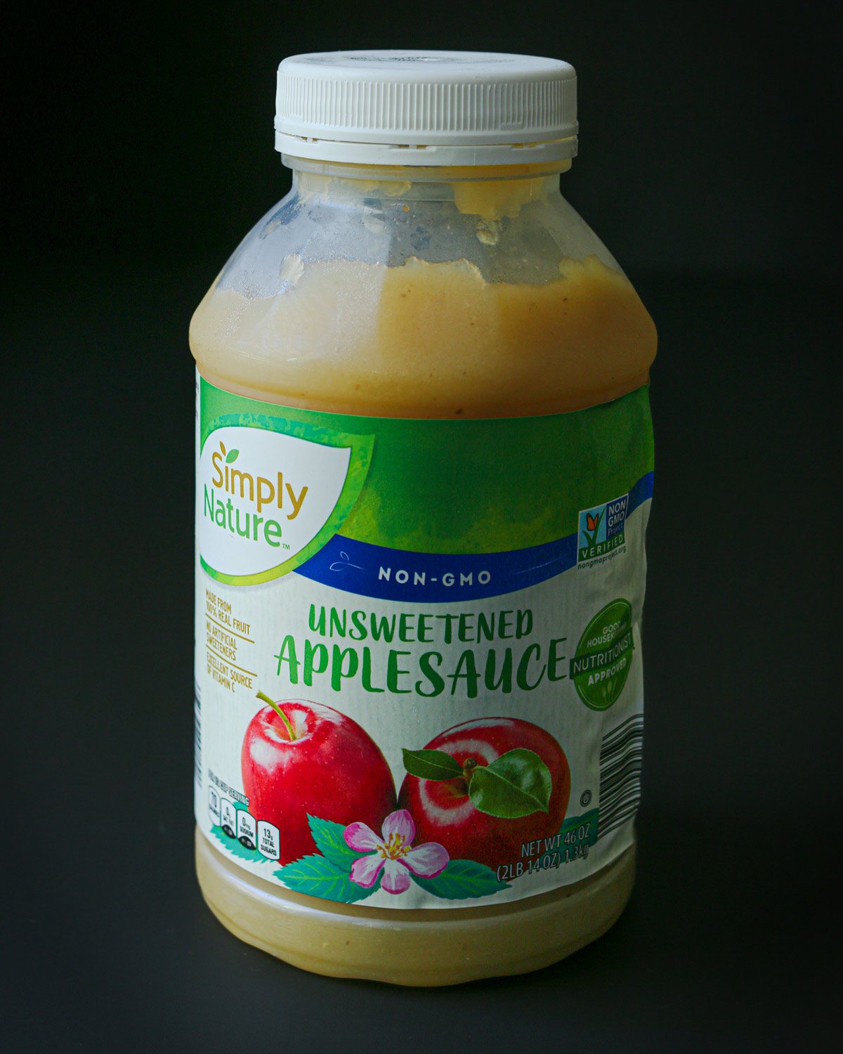 jar of store bought applesauce on table top.