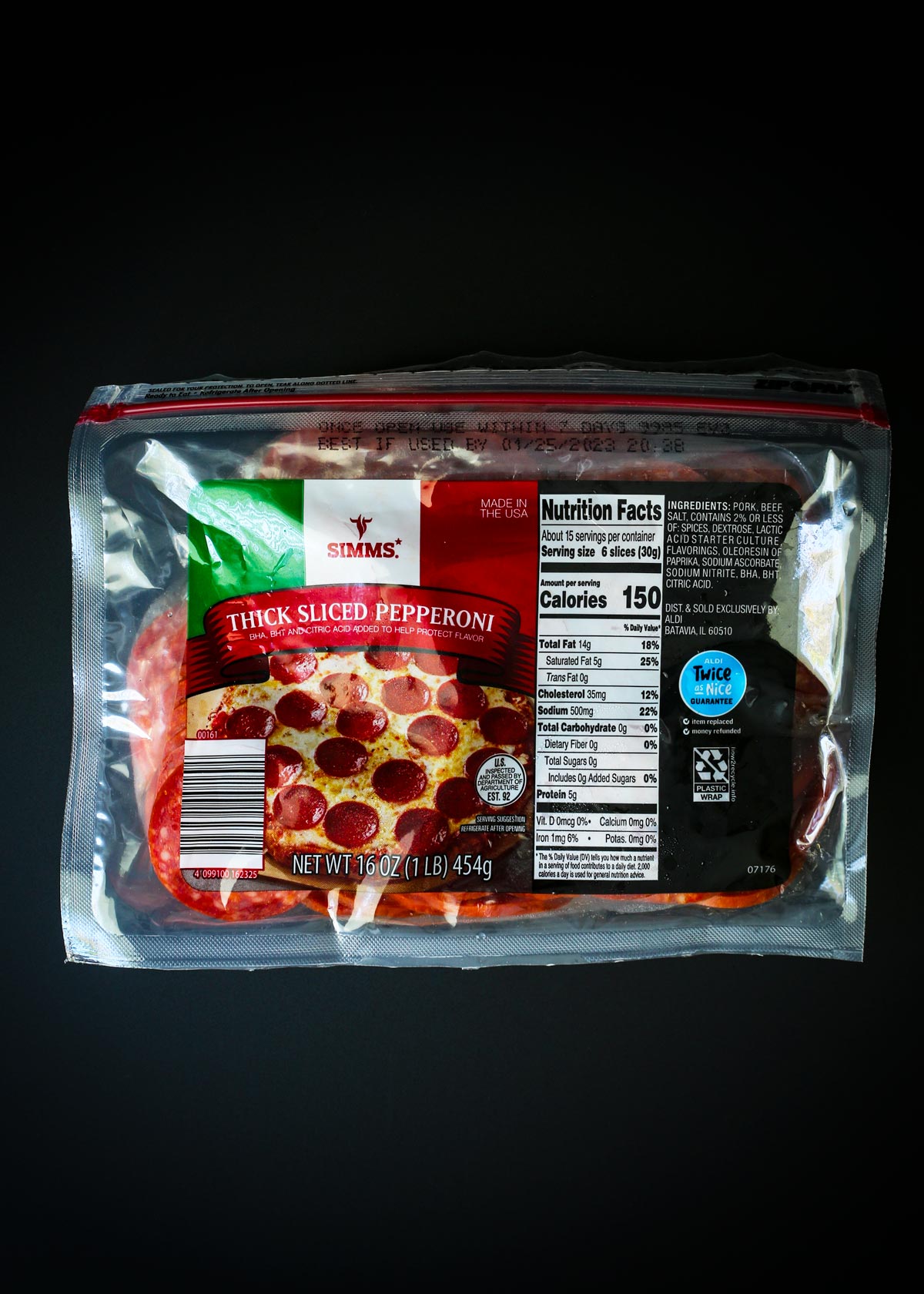 large puff pack of pepperoni slices on black table.