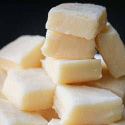 white fudge pieces stacked in a tower with a black background.