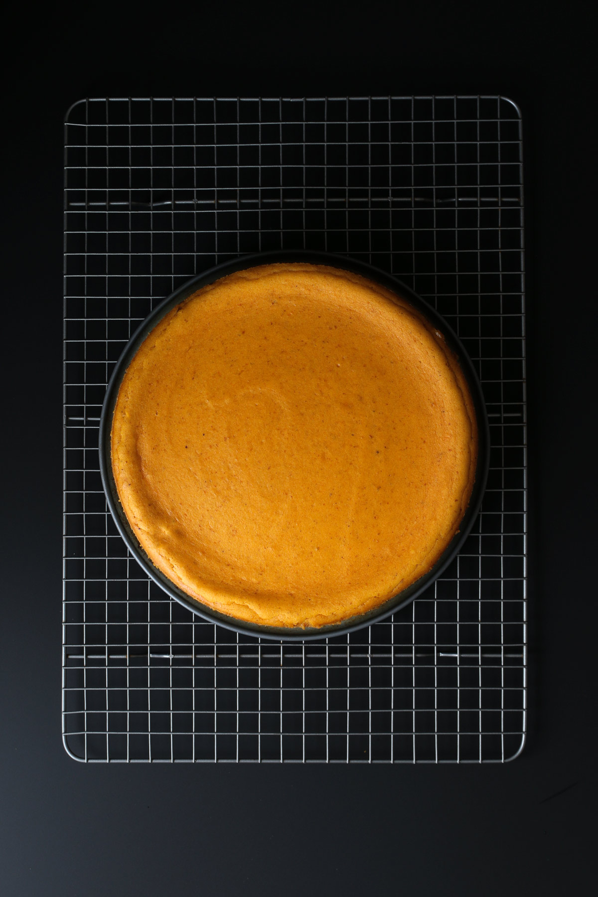 cheesecake cooling on rack with sleeve removed.