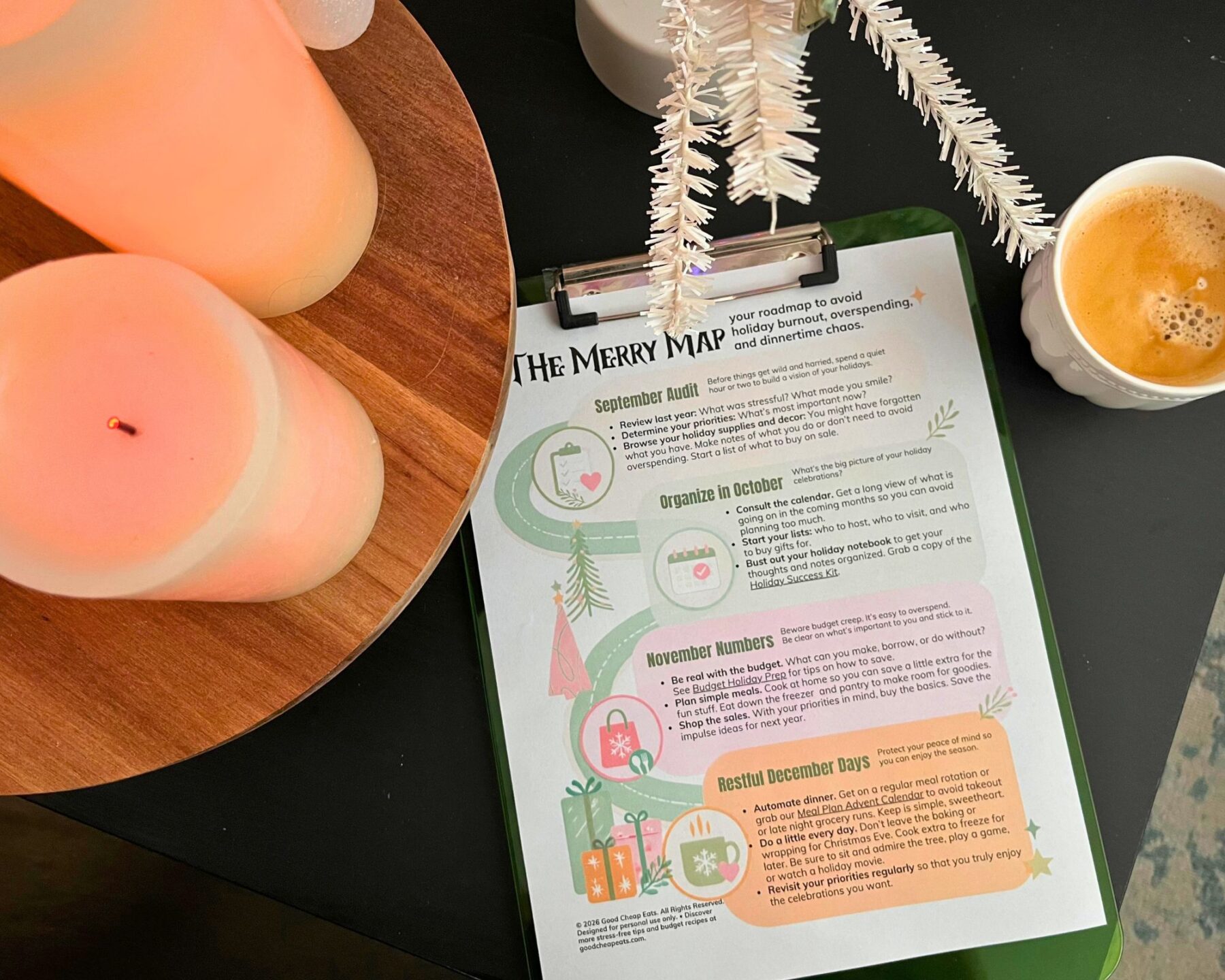 candles near a copy of the merry map on a clipboard with a cup of coffee.