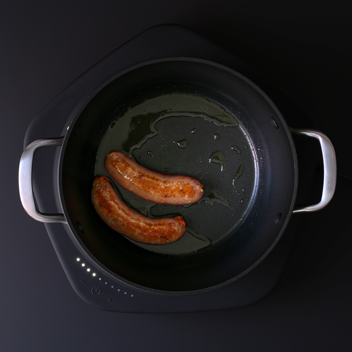 sautéing sausages in oil in the pot.