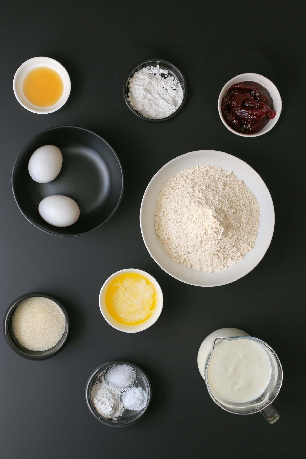 various baking ingredients laid out on a black counter.