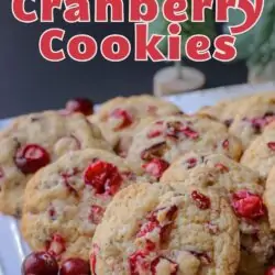 close up of cranberry cookies with green christmas trees in background.